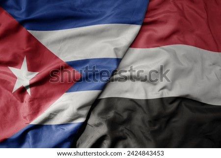 big waving national colorful flag of yemen and national flag of cuba . macro