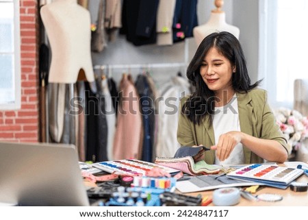 Portrait of young beautiful asian woman fashion designer stylish sitting and working with color samples.Attractive young girl working with colorful fabrics at fashion studio