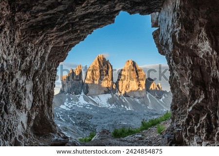 View from the cave on famous mountain peaks Tre Cime di Lavaredo, Sexten Dolomites, South Tyrol, Italy at sunrise. Drei Zinnen mountains in national park, Trentino Alto Adige Royalty-Free Stock Photo #2424854875