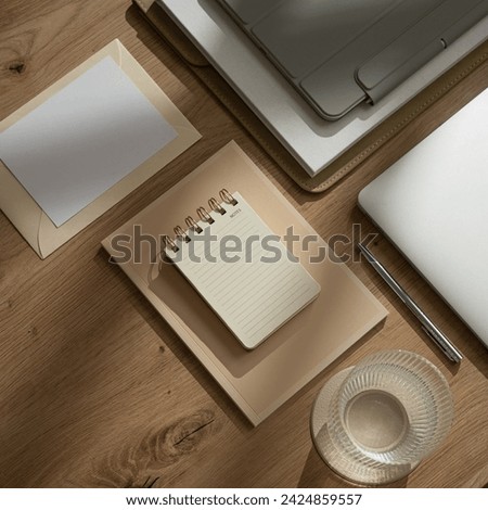 Work at home. Aesthetic office workspace with laptop computer, tablet pad, glass of water, notebook, documents, blank paper sheet with copy space on wooden table with sunlight shadows