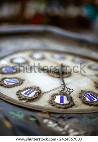 Antique clock with ornate hands and Roman numerals. The weathered metal frame showcases intricate design. Craftsmanship evident in the time-worn, detailed features. Royalty-Free Stock Photo #2424867039