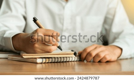 businessman working at work table,home office desk background, checklist writing planning investigate enthusiastic concept. Male hand taking notes on the notepad.