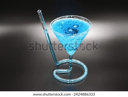 Vibrant blue martini cocktail drink on black background