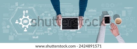 Top view of hands using digital tablet and mobile phone with symbol of workshop concept