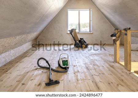 Cleaning wooden floor with vacuum cleaner after sanding, grinding renovation, preparation for varnishing Royalty-Free Stock Photo #2424896477