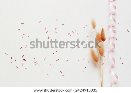 Dry flower branch, ribbon and candy sprinkles on a light gray background. Springtime, Easter, Birthday, Happy Women's Day, Mother's day concept with copy space. Top view, Flat lay
