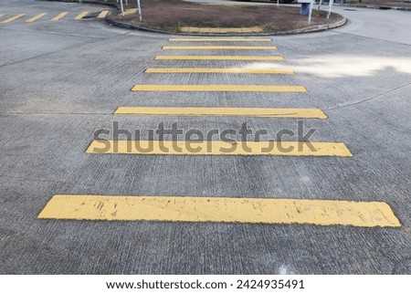 cross road with yellow lines painted on the road. 