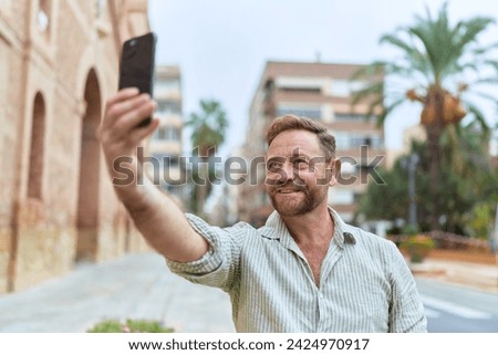 Middle age man smiling confident making selfie by the smartphone at street