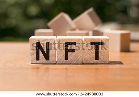 Concept word NFT on wooden cubes. Inscription on a financial, business or economic theme. NFT - short for Non Fungible Token