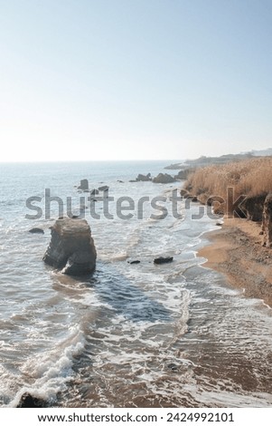 rocky seashore on a sunny day and waves on the water
