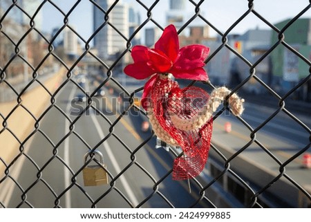 Symbolic attachments on a fence with a blurred background of an urban roadway, Boston, USA