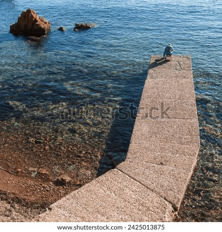 Var, Côte d'Azur, seaside in Saint-Raphaël with rocks and Mediterranean Sea and pontoon with fisherman Royalty-Free Stock Photo #2425013875