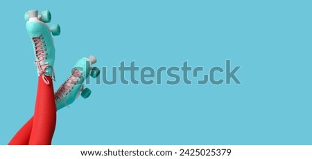 Legs of young woman in vintage roller skates on blue background with space for text Royalty-Free Stock Photo #2425025379