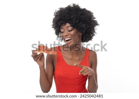 Fashionable young African American woman with a slice of her favorite pizza.