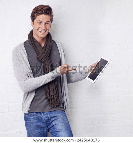 Excited man, portrait and pointing to tablet screen for advertising or marketing on a white studio background. Happy and handsome male person with smile, showing technology display or mockup space