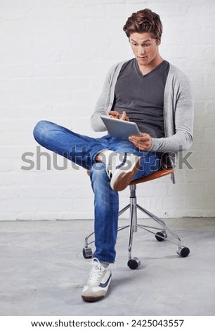Man, chair and tablet with surprise for online technology on wall background for communication, streaming or internet. Male person, wow and digital search for connectivity, gaming or social media