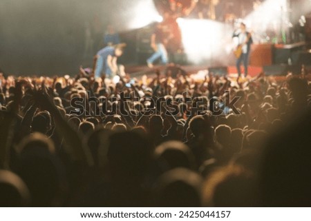 Crowd, live concert and stage with dancing audience as music festival for entertainment, performance or carnival. People, hands and fans of musicians with lighting for rock event, rave or vacation