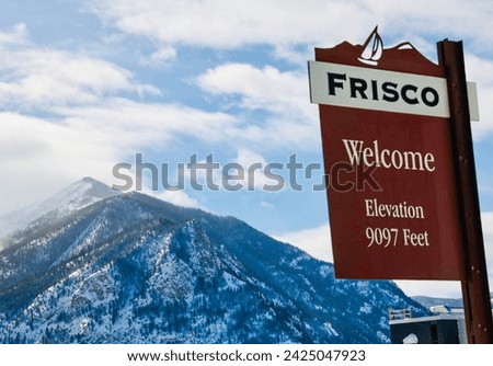 Welcome to Frisco Colorado sign with mountains in the background covered with snow. Elevation 9097 feet high altitude. USA 2024