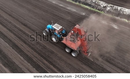 Peat Harvester Tractor on Collecting Extracting Peat. Mining and harvesting peatland. Area drained of the mire are used for peat extraction. Drainage and destruction of peat bogs. Royalty-Free Stock Photo #2425058405