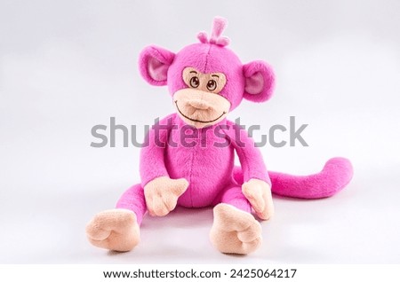 Plush children's toy pink monkey on a white background.