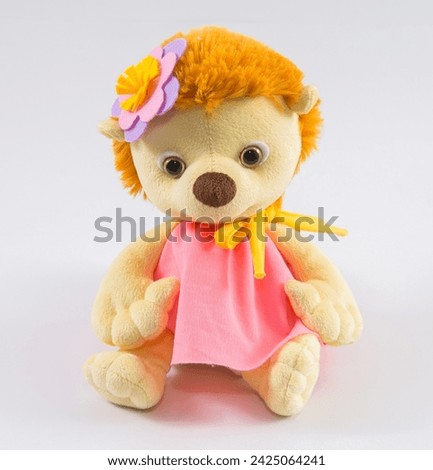 Cute plush hedgehog girl in a dress and with a flower on her head on a white background.