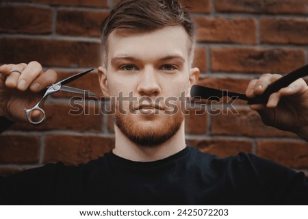 Barber man hold scissors on brick background. Card for Barbershop hairdresser salon, retro toning.
