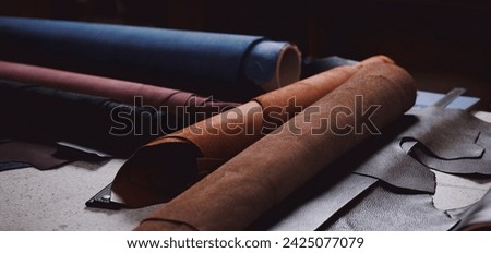 Banner Tailor on background different rolls natural brown leather, top view.