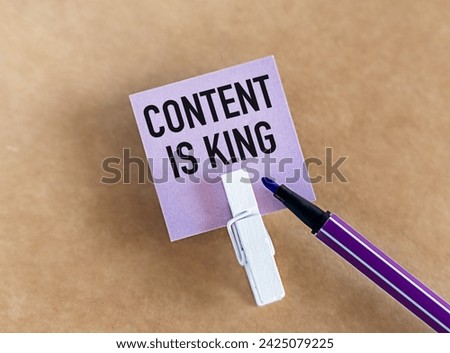 Purple paper pinned to brown paper with marker beside it. Content is King written in capital letters. This image highlights the importance of quality content in digital marketing strategies.