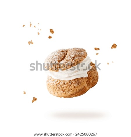 Cream puffs, pastry from choux filled vanila cream covered sugar powder and crumbs closeup falling flying isolated on white background. Sweet french dessert Choux for coffee break or party.