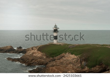 Panoramic view of the lighthouse of Illa Pancha on the coast of Lugo in Galicia, Spain. Nice landscape on a cloudy day.