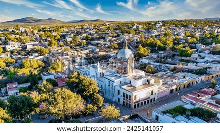 Expansive aerial panorama of the 'Pueblo Mágico' Mineral de Pozos, highlighting the iconic parish dome amid the charming village setting.