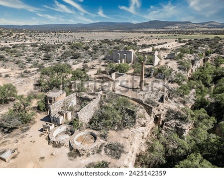 Aerial view of the ancient Jesuit mine ruins at Mineral de Pozos, Guanajuato, showcasing colonial era architecture amidst a rugged desert landscape.