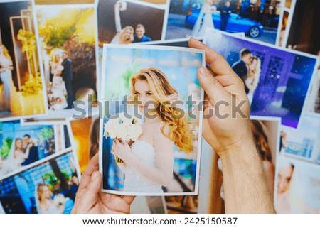 men's hands lay out Beautiful printed wedding photos on a wooden surface. Professional photography and photo printing.