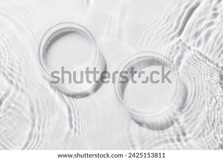 Two Petri dishes on a rippled white background. Abstract nature background of product presentation. Flat lay cosmetic mockup, space for copy .