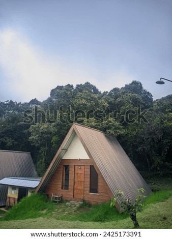 A triangular house picture in forest.