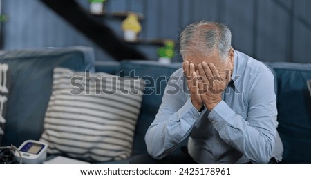 Worried retired old senior man sitting alone on sofa sorrow anxiety at home. Unhappy Indian middle aged male grieving think lonely depressed pensive suffering health problems Royalty-Free Stock Photo #2425178961
