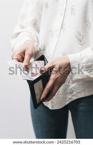 Woman's hands taking out money from wallet, Ukrainian Hryvnia banknote cash.