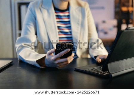 Businesswoman s hands typing on smartphone, tablet and laptop keyboard computer, typing, online in modern office
