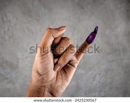 Showing a hand with purple ink on the little finger after the Indonesian presidential election or the 2024 election