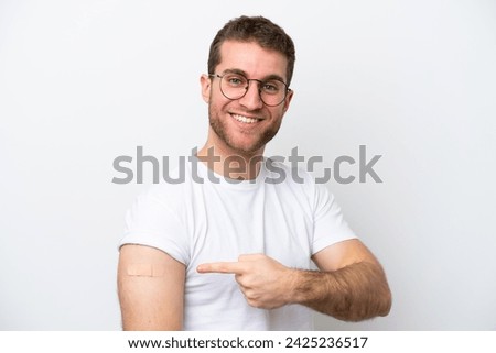 Young caucasian man wearing band aids isolated on white background and pointing it
