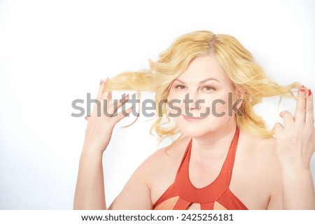 Middle-Aged Blonde Woman Displaying Her Unkempt Hair Against a White Background