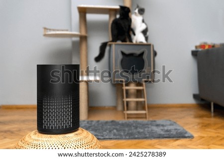 air purifier in the area with pets or cat. Air Pollution Concept. Air purifier, filters out invisible viruses, allergens or pollutants in the house on a cat tree background. Cute cat and Air purifier Royalty-Free Stock Photo #2425278389