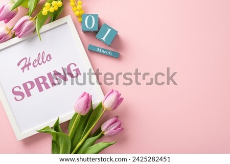 Fresh start vibes! Top view of a photo frame reading "Hello Spring," cubes calendar on March 1st, mimosa, and tulips on a soft blue backdrop. Ideal for text or ads