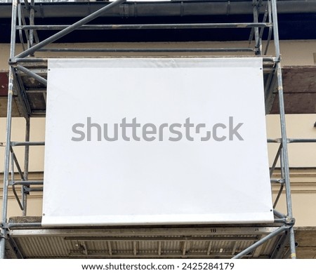 Scaffolding banner with space for banner advertising on the house facade Royalty-Free Stock Photo #2425284179