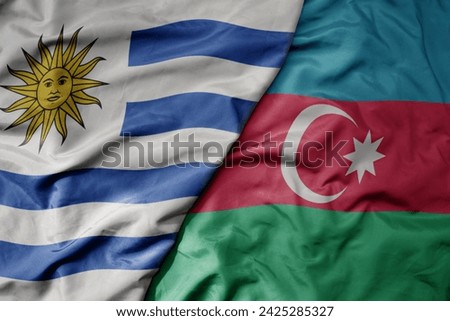 big waving national colorful flag of azerbaijan and national flag of uruguay . macro