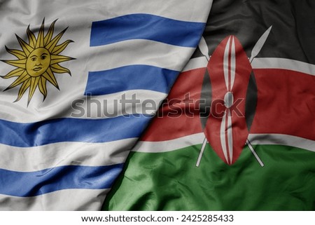 big waving national colorful flag of kenya and national flag of uruguay . macro