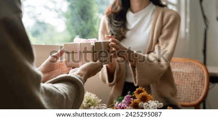 Romantic young asian couple embracing giving present in living room at home. Fall in love. Valentine concept