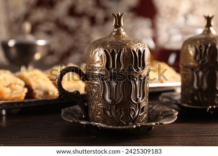 Traditional Turkish tea and fresh baklava served in vintage tea set on wooden table