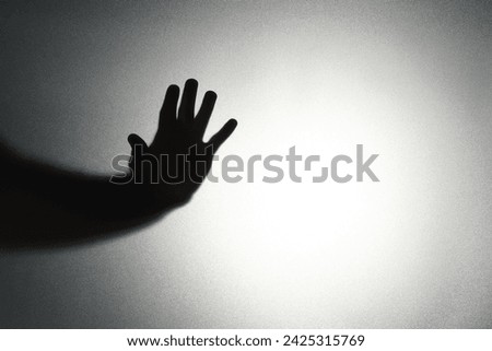 Silhouette of ghost behind glass against light background, closeup. Space for text