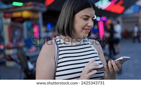 Young beautiful hispanic woman smiling happy using smartphone at Prater Vienna